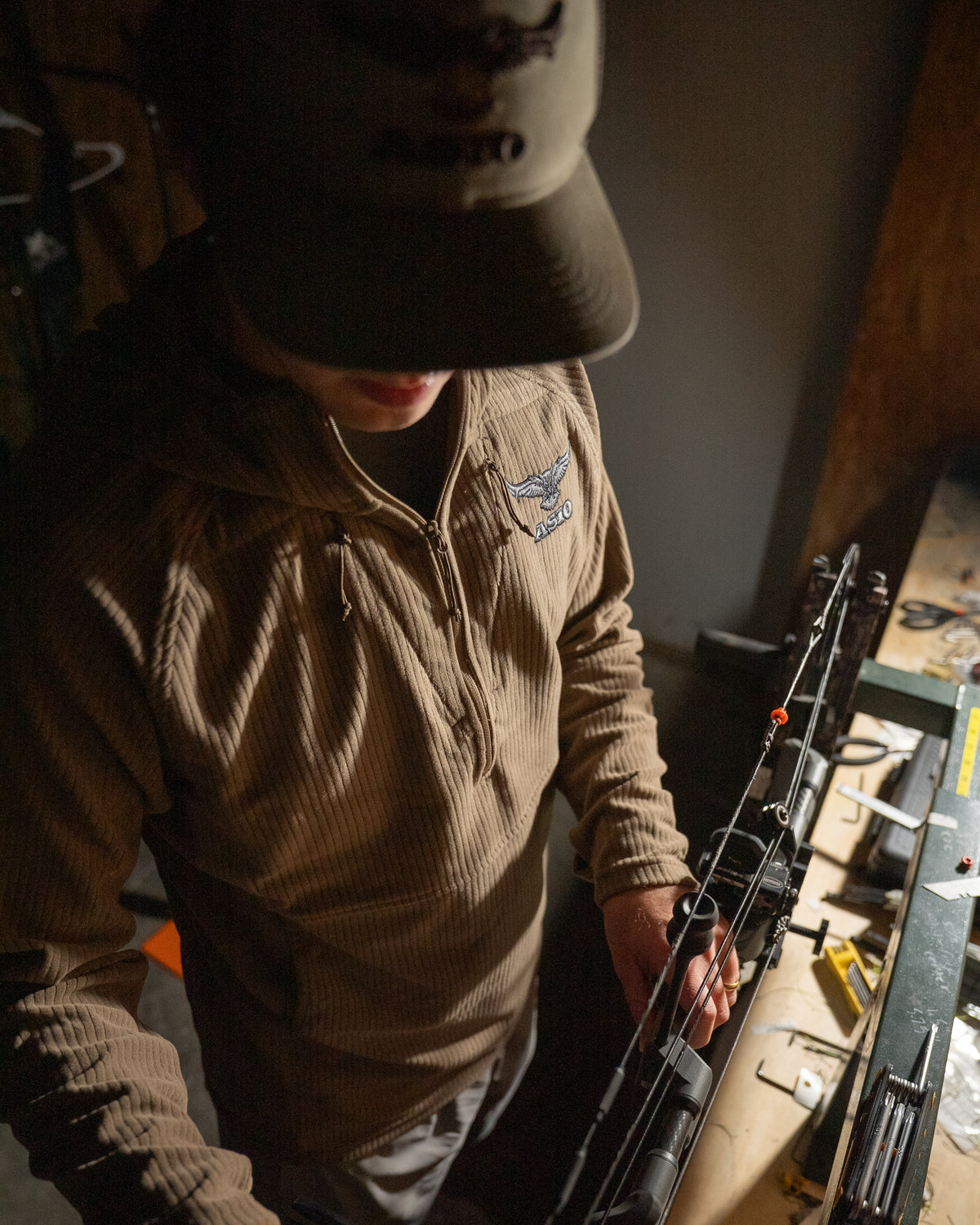 ASIO Gear hunter using bow press wearing midweight hoodie field brown