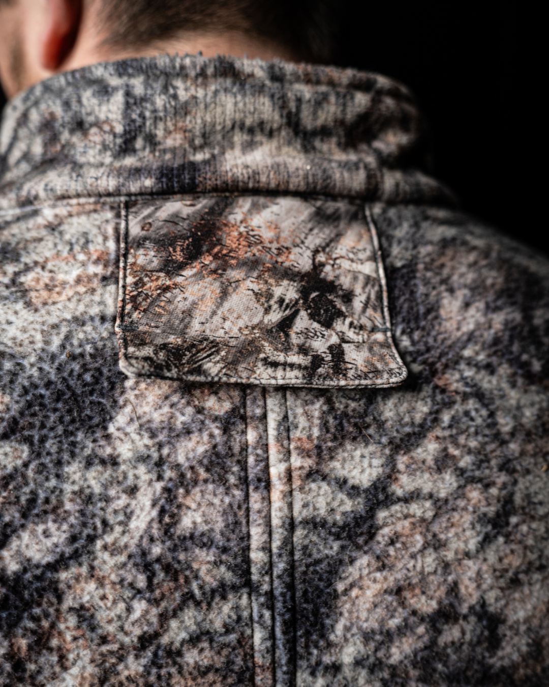 Rear view of the ASIO Gear Midweight Sherpa Jacket featuring a concealed tree harness pass through port for safe and comfortable treestand hunting.